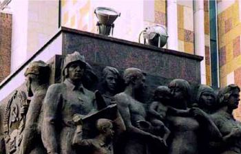 Горельефные и рельефные изображения на двух стелах, фланкирующих главный вход в постамент монумента Рабочий и колхозница